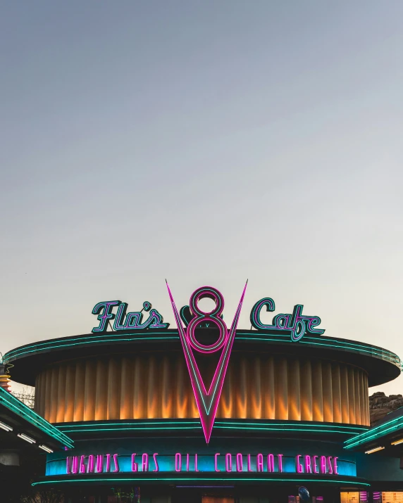 the outside of a theater with an illuminated sign above it