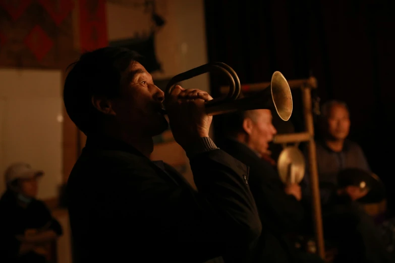 a man holding a trumpet with people in the background