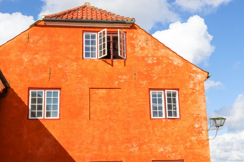 two windows on a house with red painted walls