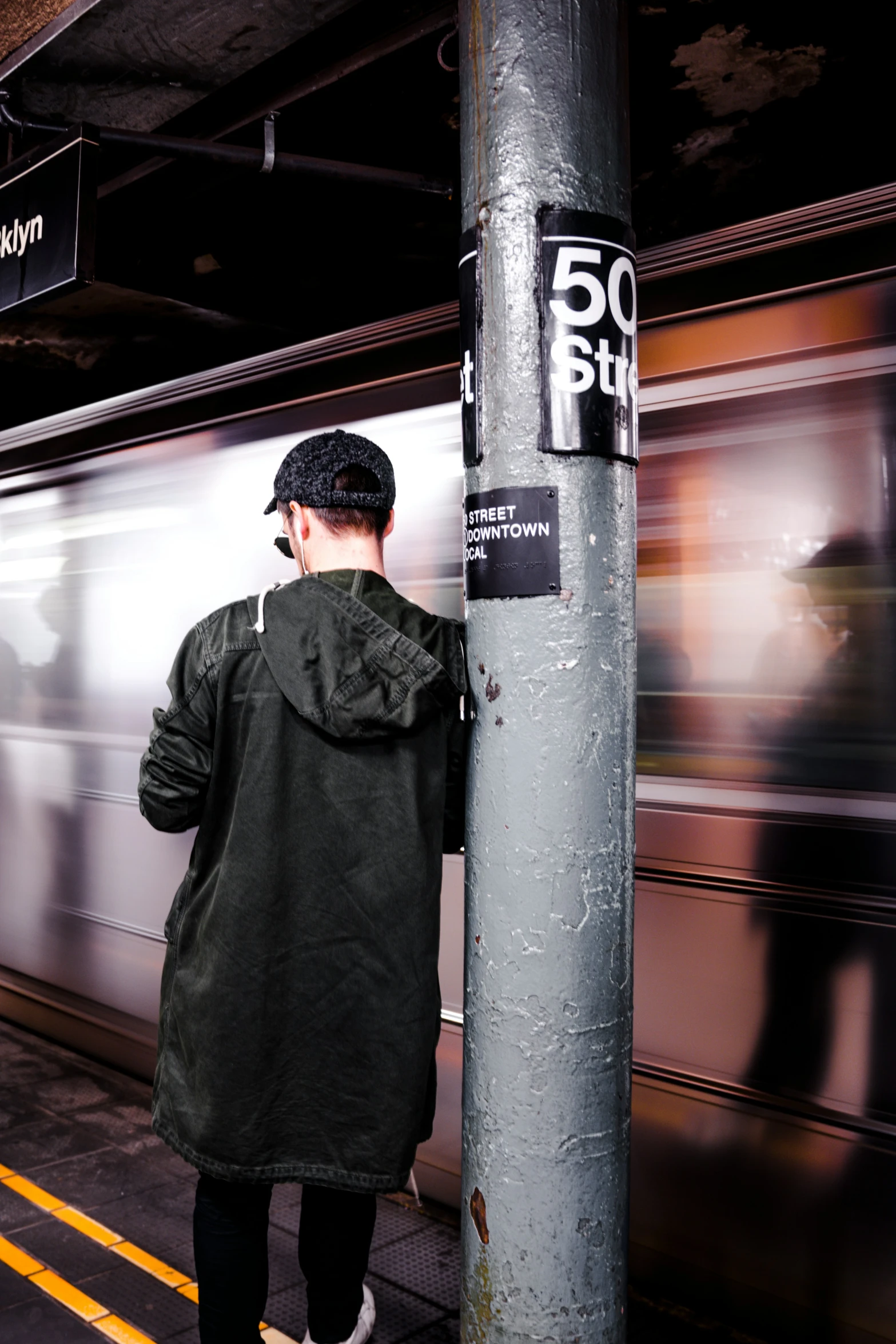 a man that is standing next to a pole