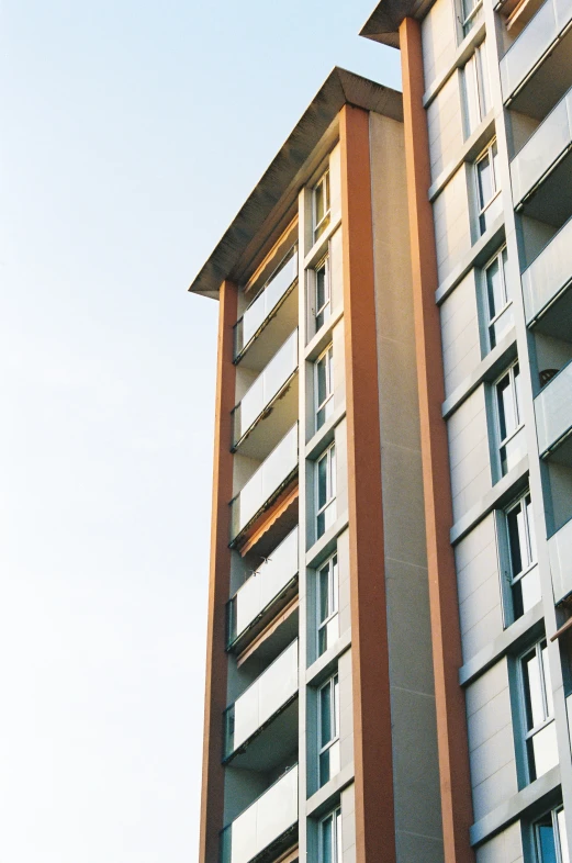 a tall building with brown and white trim and windows