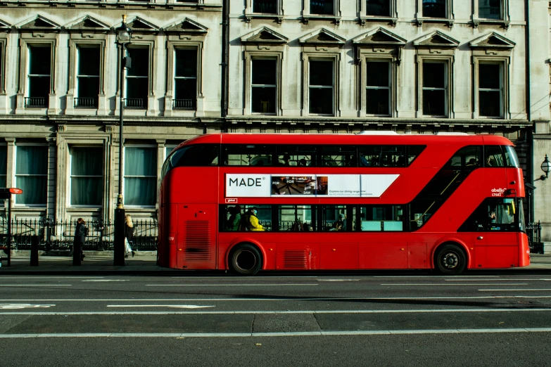 a double decker bus driving in front of a building