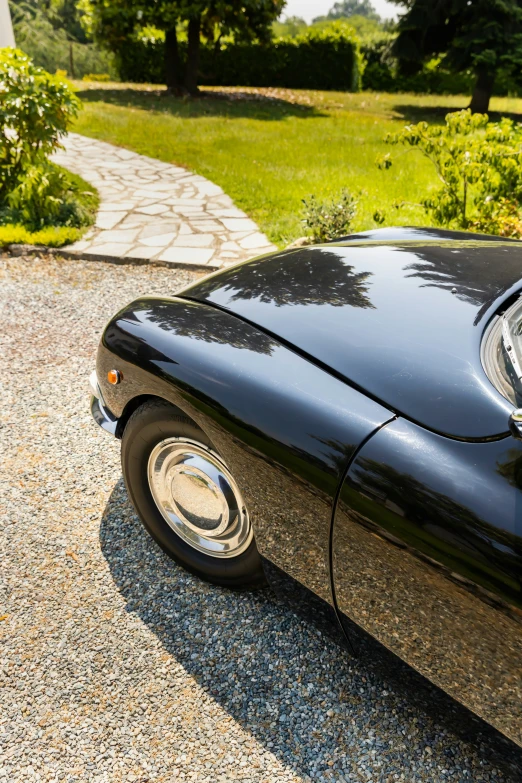 an old black sports car is parked outside