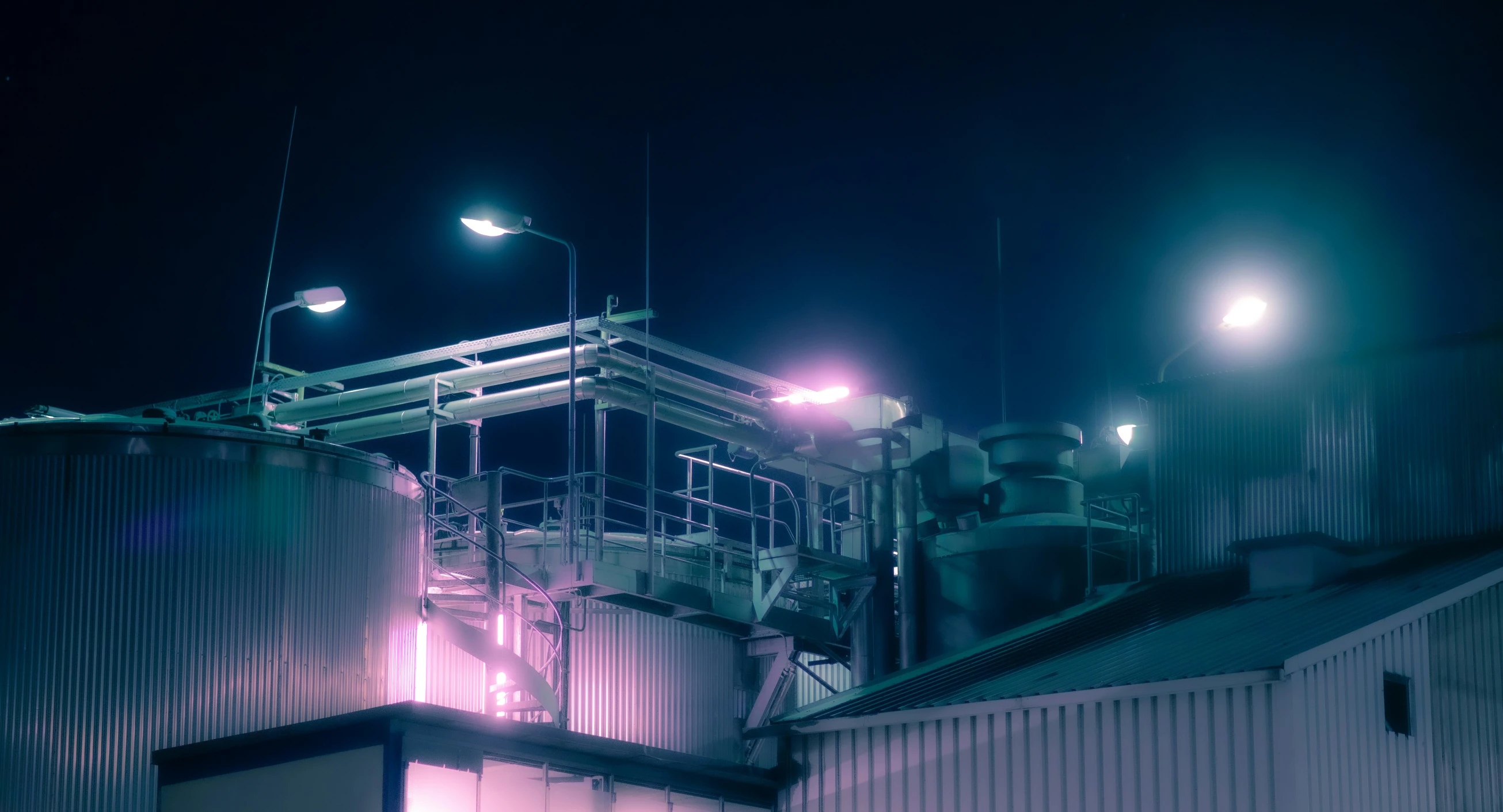 an industrial silo on the side of a building at night