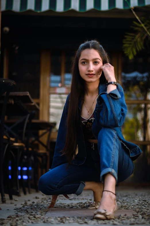 a young woman sitting on the ground next to a table