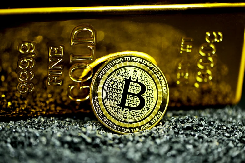 a bit coin lying next to a yellow wallet