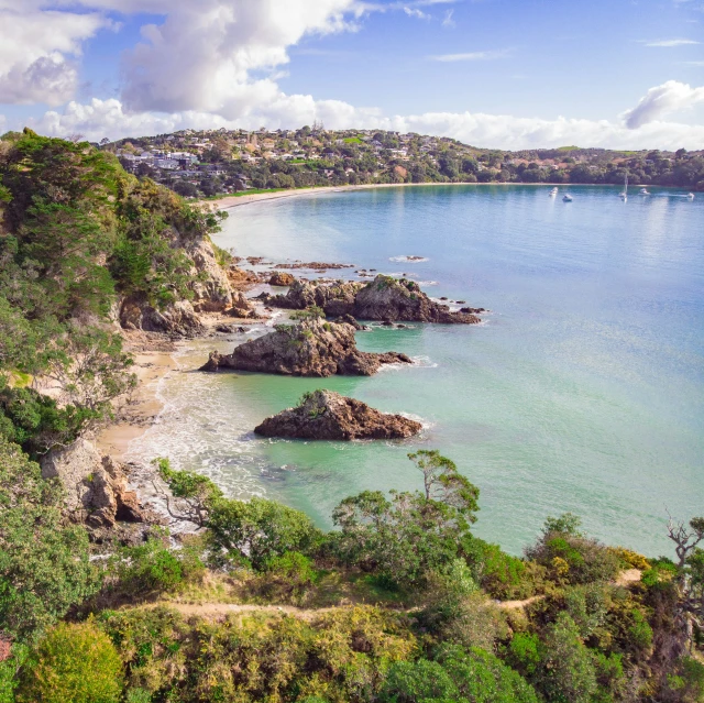 a scenic po of a coastline with green trees and bushes on the shoreline