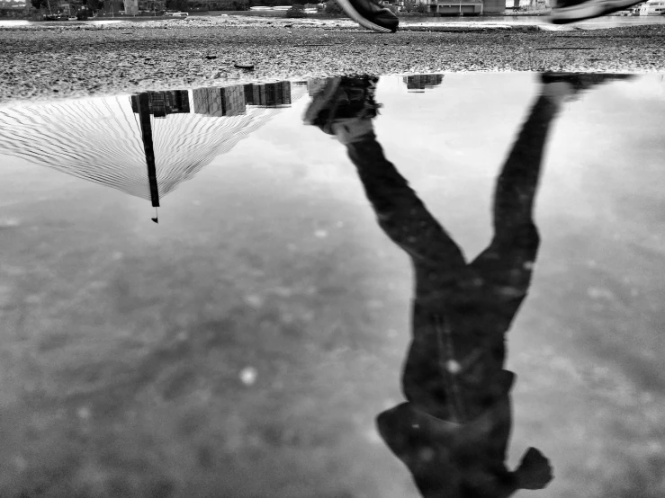 a man holding his hands up in the air with his reflection