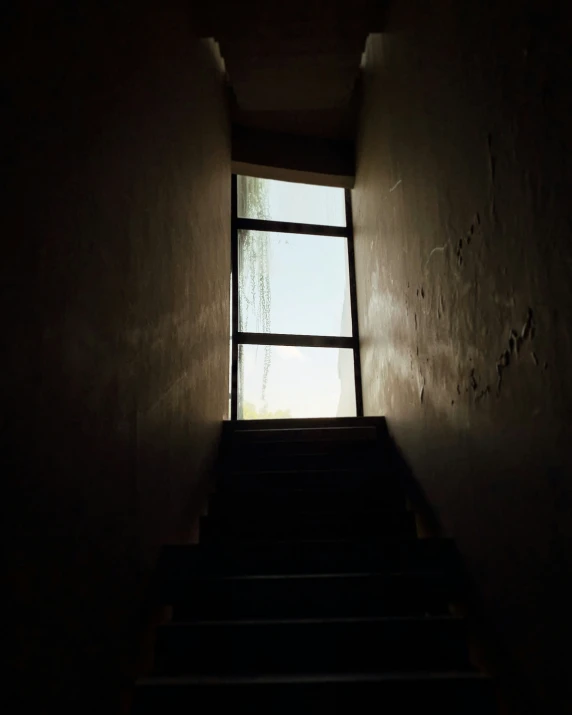 dark hallway with light coming through the window and stair leading up