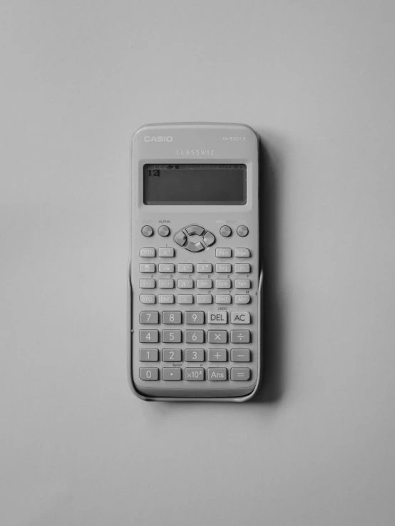 a calculator sitting on a table next to a white background