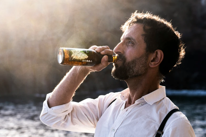 a man with beard drinking a beer from a bottle