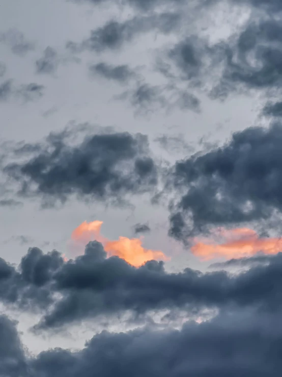 an airplane flying through a cloudy blue sky