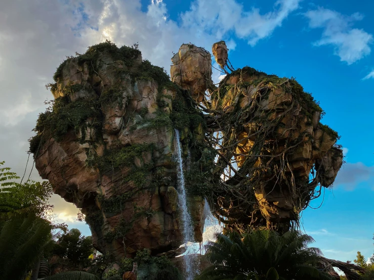 a large artificial waterfall surrounded by trees and vegetation