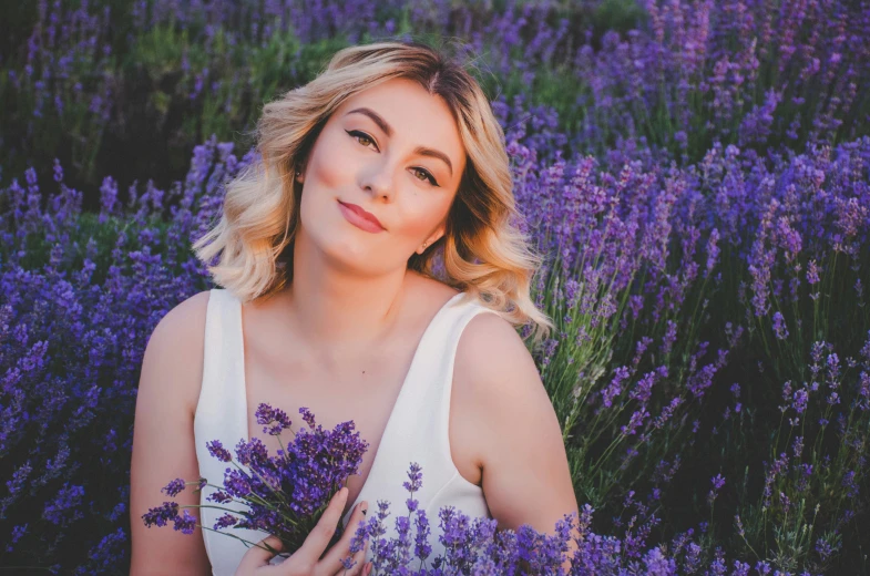 the model poses for an image with lavender flowers
