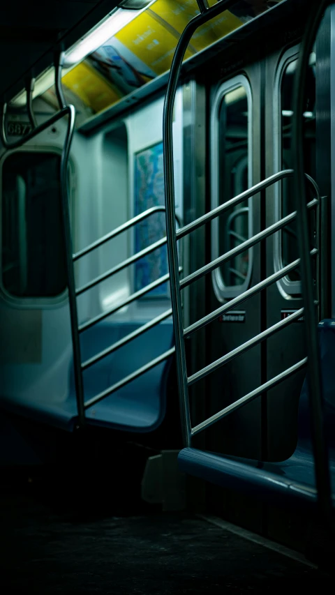 a metal railing near a subway train in the dark