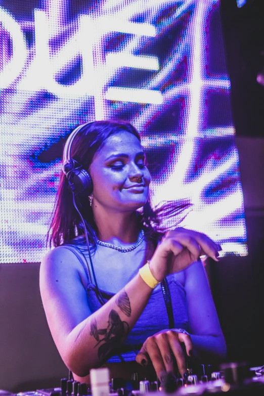 a person sitting at a djs booth with headphones on