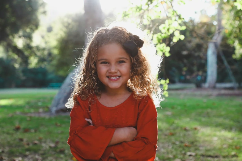 a smiling girl standing in a field