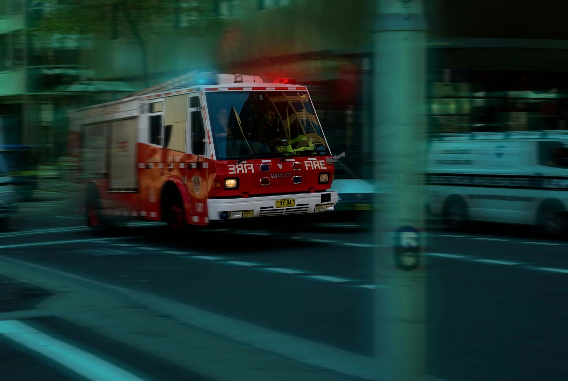 an ambulance is driving down the street on fire trucks