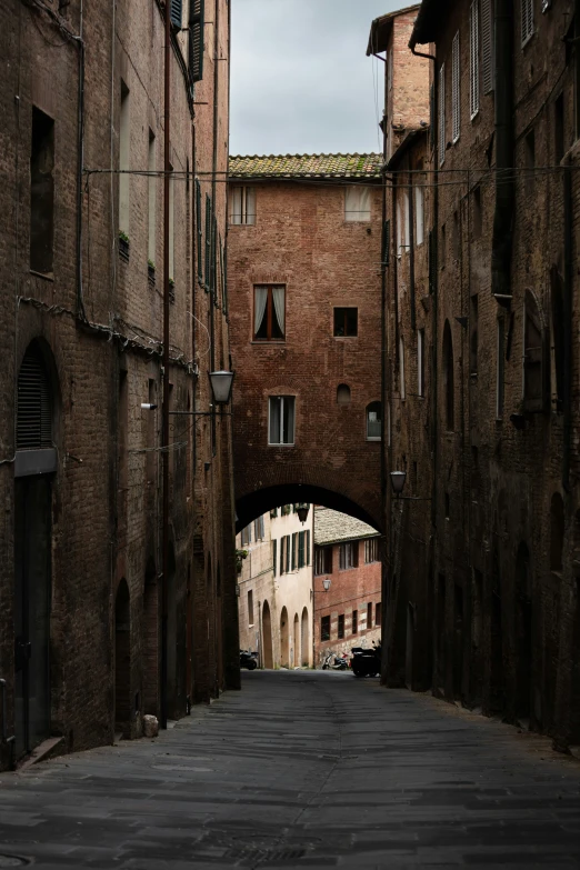 a narrow street with brick buildings on either side