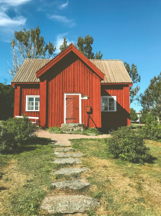 a red building is shown in the middle of grass