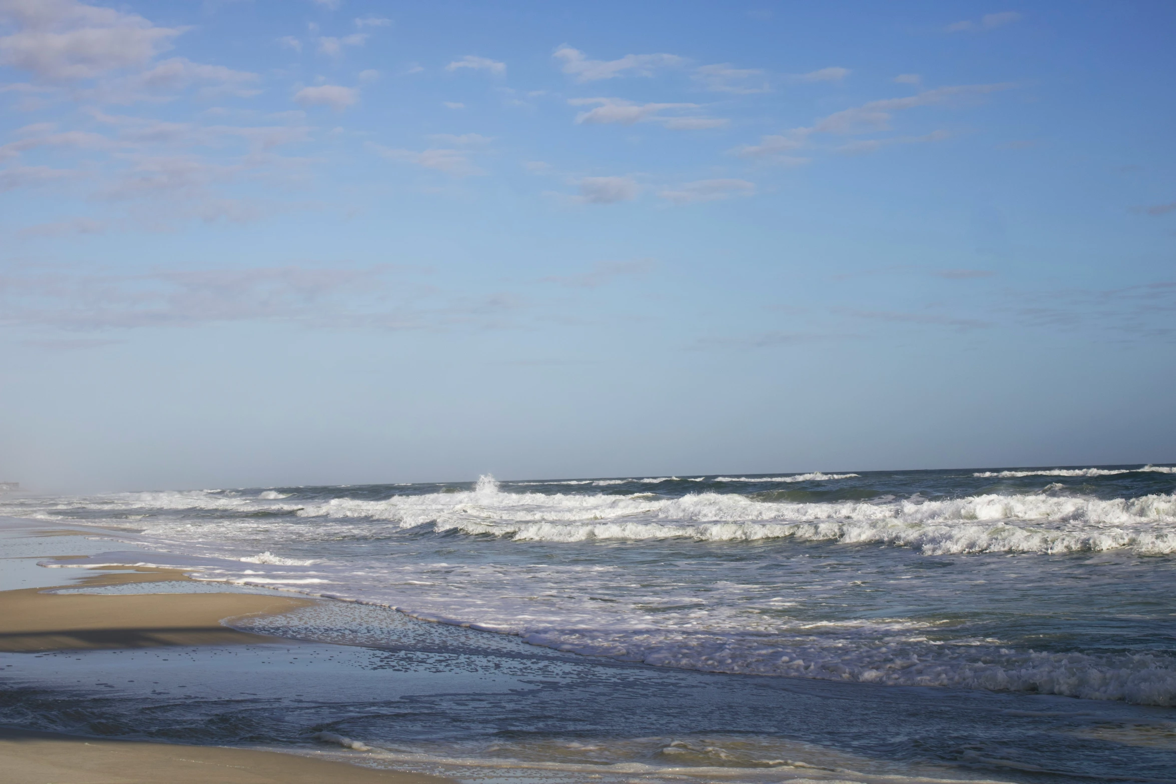 a person standing at the beach with surfboard