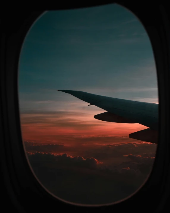 the wing of a jetliner with a sunrise in the background