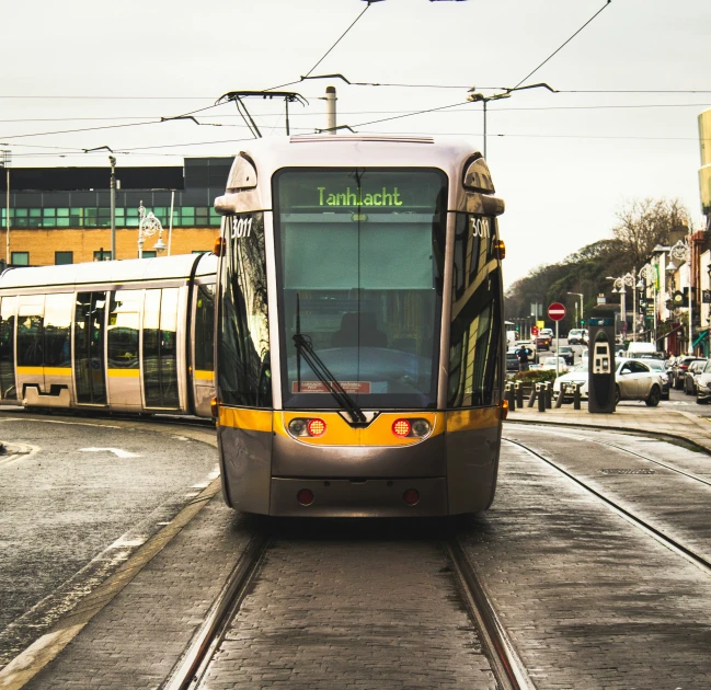 a trolley moving along a city street on its track