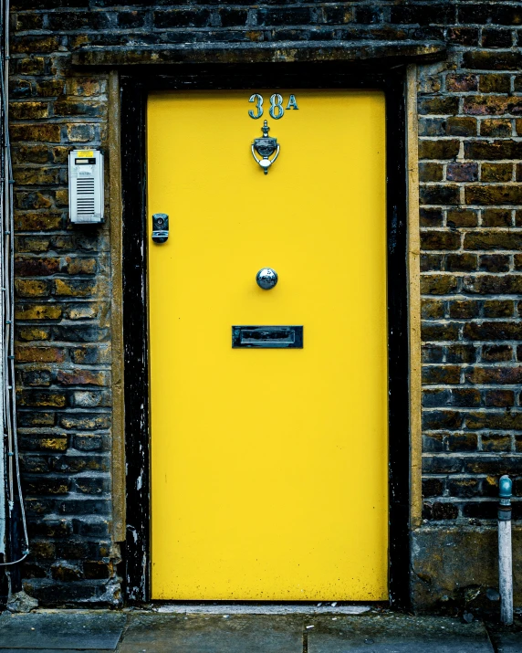 a yellow door in front of a brick building