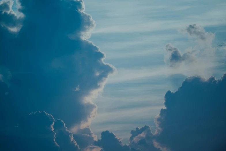 a large cloud filled sky above some hills