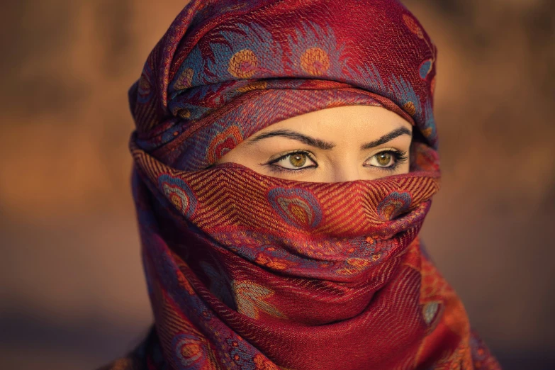 a woman wearing a red hijab with blue eyes