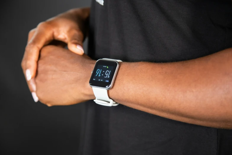 person showing off their white band with a clock on the watch