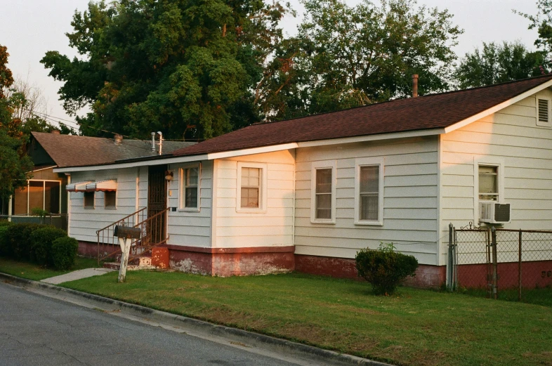 small white house sitting on the side of a road