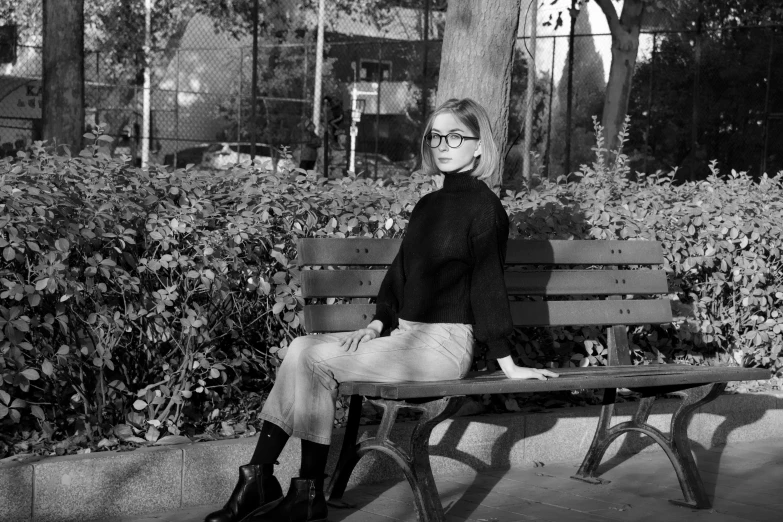 a woman in glasses sitting on a bench