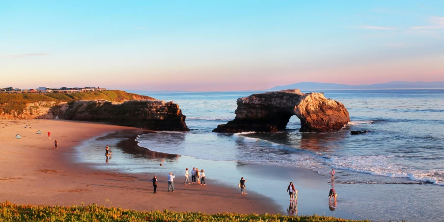 a group of people on a beach next to the water