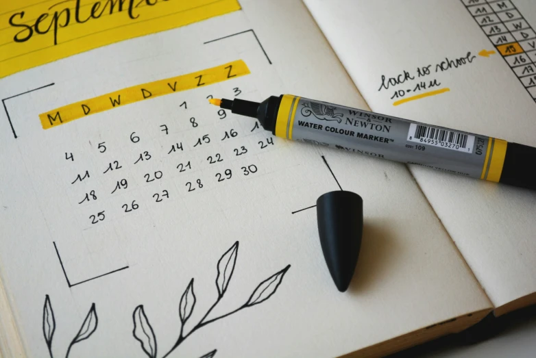 a bullet pen laying in front of an open calendar