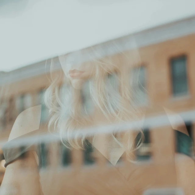 woman wearing dress posing in front of window of business building