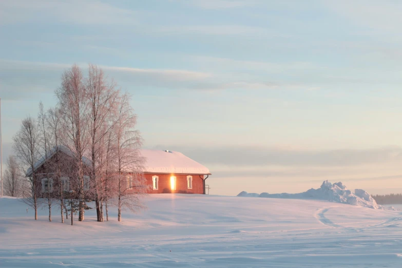 a house is seen sitting on top of a snowy hill