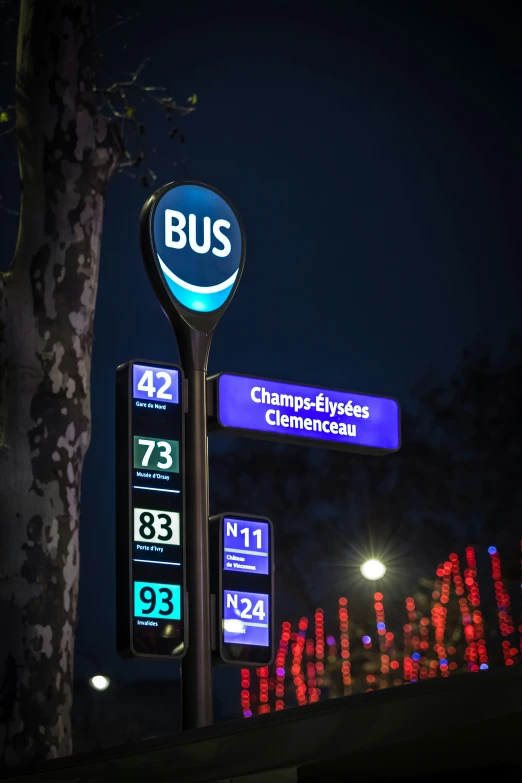 a gas station sign with lit signs in the night