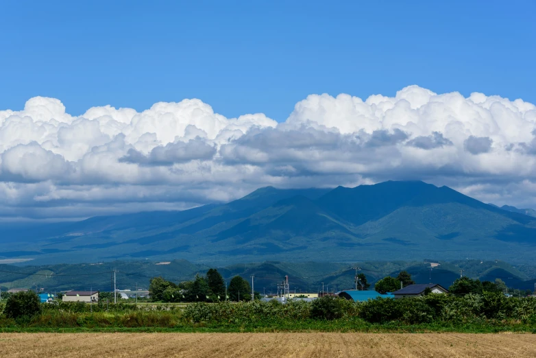 a large mountain and clouds in the distance