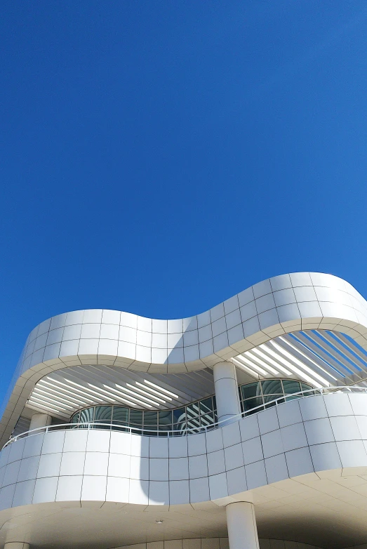 white building against a blue sky with a spiral shaped design on the front