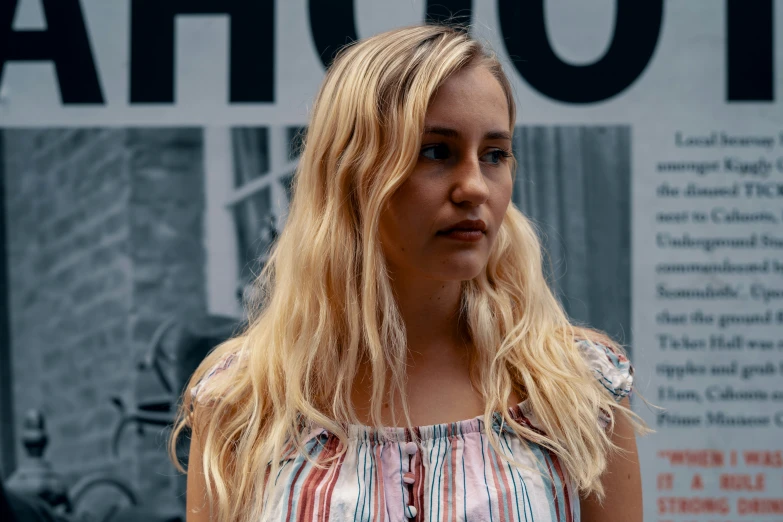 the woman is standing near a wall in a po