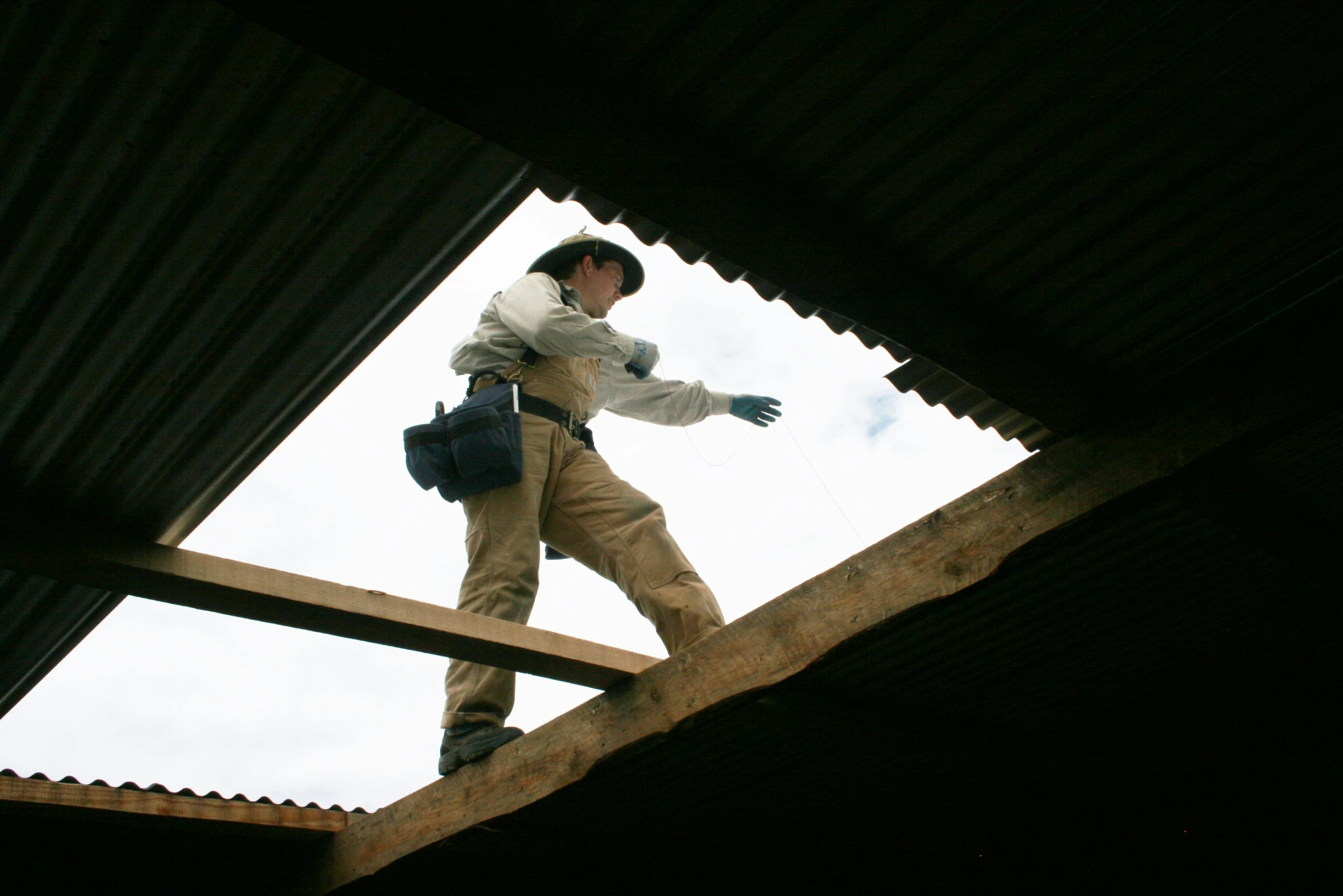 a man standing on top of a roof in an unfinished structure