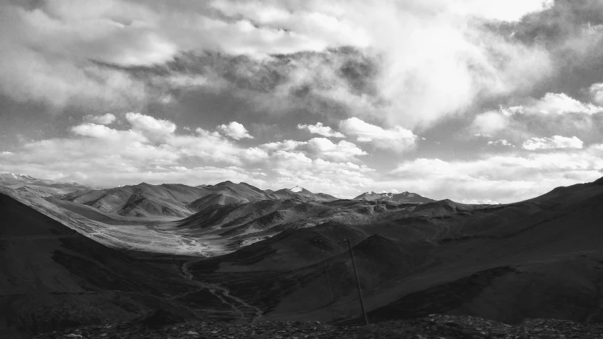 black and white po of mountains under cloudy sky