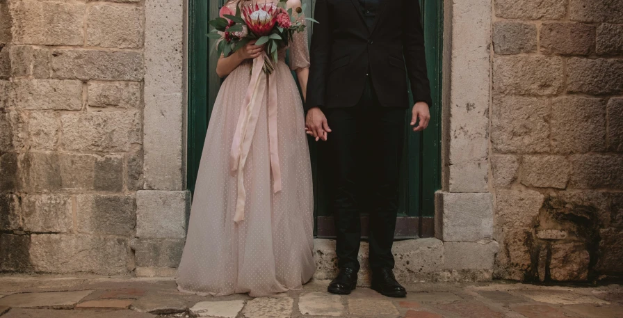 a bride and groom posing outside of their venue