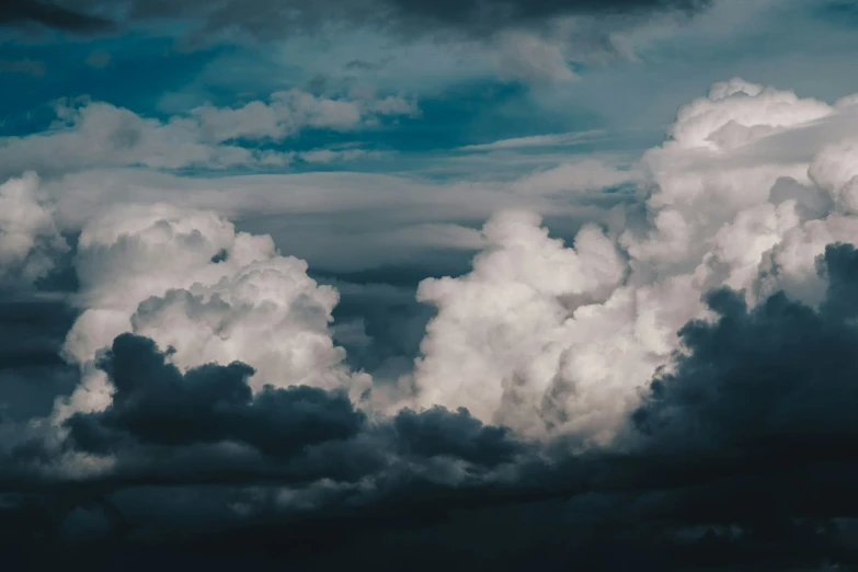 large clouds float in the sky above an airport runway