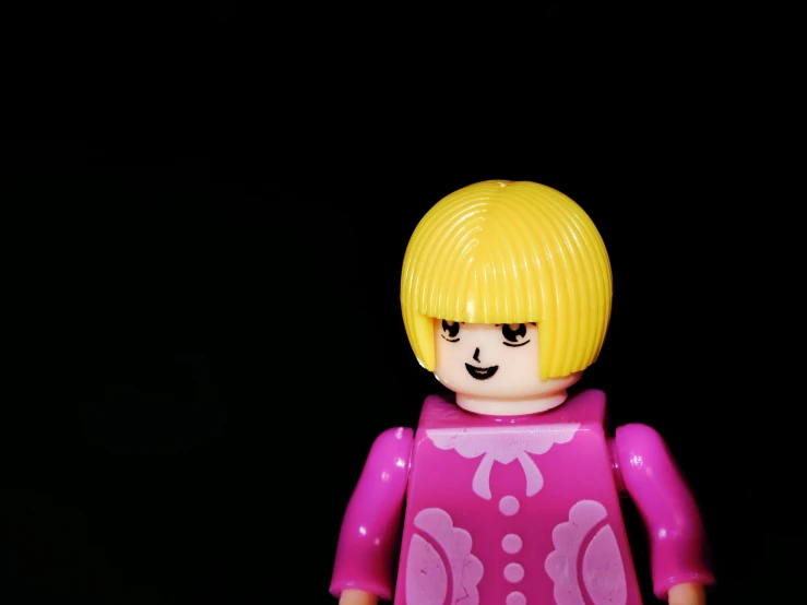a lego girl with yellow hair and green eyes