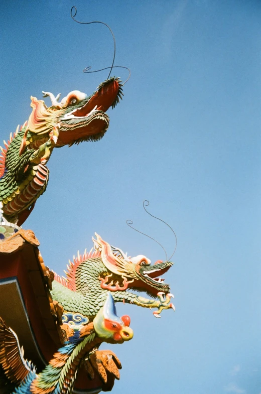 a dragon statue sitting in front of a sky background