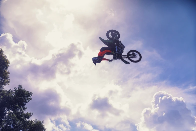 a man on a bike performs aerial tricks