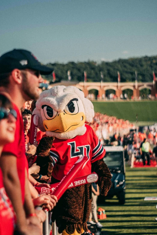 a mascot wearing a red uniform while holding a baseball bat