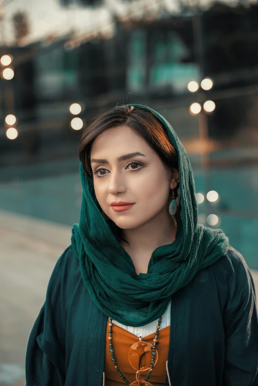 a woman in green headscarf posing for a po